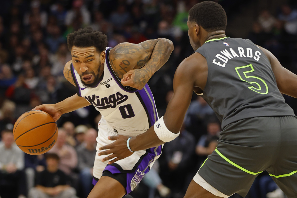 Mar 1, 2024; Minneapolis, Minnesota, USA; Sacramento Kings guard Malik Monk (0) works around Minnesota Timberwolves guard Anthony Edwards (5) in the first quarter at Target Center.